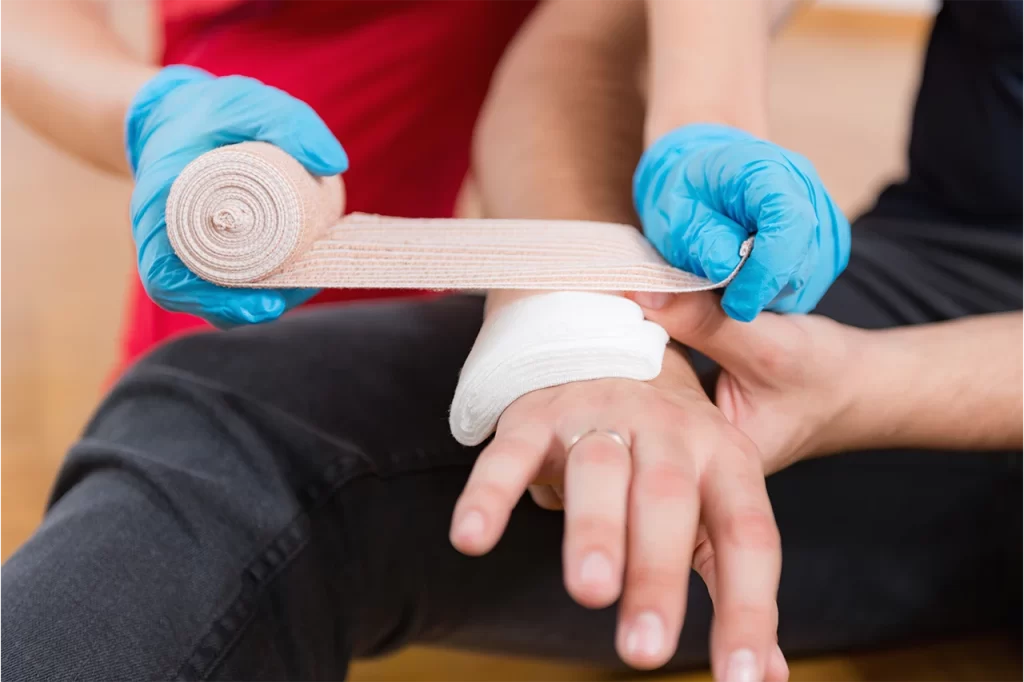 A person applying a bandage to a hand
