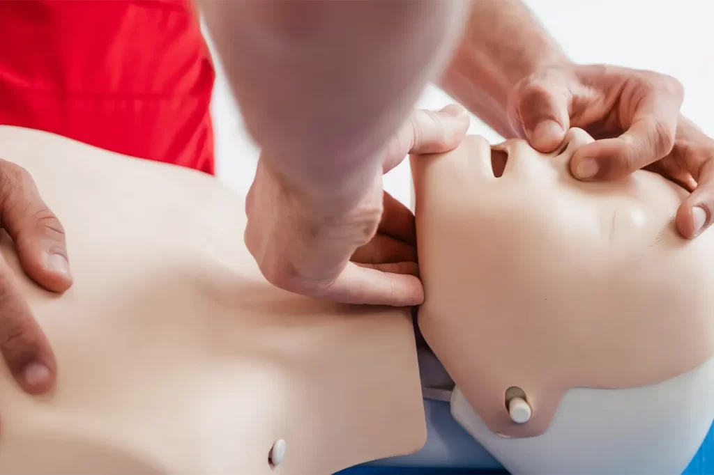 A man performing CPR on a dummy