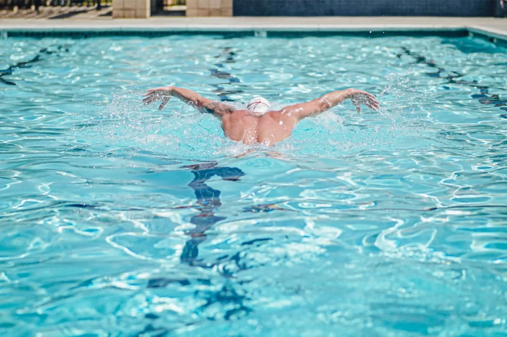 A male swimming doing butterfly in a pool